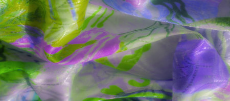 Swirling green and purple fabric with bright neon highlights, creating a vibrant flowing pattern.
