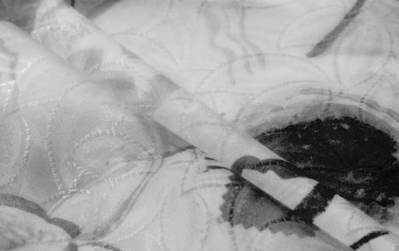 An artistic black-and-white abstract of a textured fabric, emphasizing natural folds and layered...