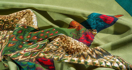 A detailed artistic illustration of multiple flying pheasants on a light green fabric with colorful...