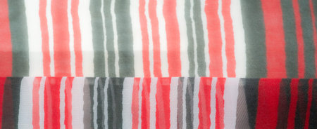 A vibrant and dynamic red, white, and green striped fabric with an elegant draped texture. The...