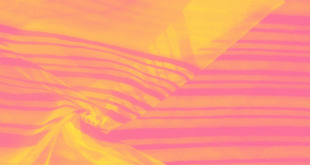 An abstract fabric design featuring soft folds and ripples in pink and yellow hues. The alternating stripes create a sense of movement and depth, enhancing the fabric's dynamic appearance.の写真素材