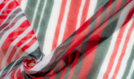 A close-up shot of a flowing fabric with vibrant red, black, and white stripes. The folds create dynamic patterns, highlighting the intricate texture and vivid contrast of the colors. Perfectの写真素材