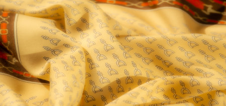 Soft and elegant, this yellow textile features a repetitive stirrup pattern. The fabric's smooth texture and intricate design make it perfect for clothing, accessories, or home decor.の写真素材