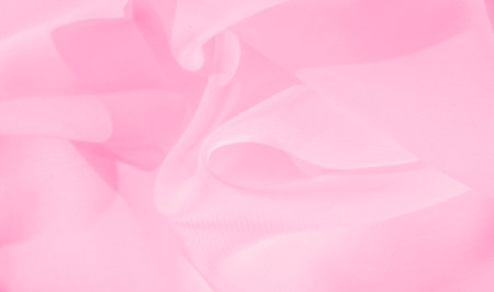 Blurred light pink fabric gracefully drapes in a soft, flowing manner, forming subtle waves and folds. The gentle movement of the material adds a sense of tranquility and fluidity.の写真素材