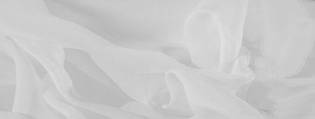 Blurred white fabric, folded in soft, flowing patterns. The texture and subtle shadows create a...
