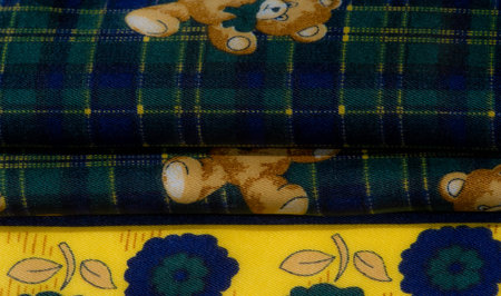 Blur of a charming fabric featuring yellow floral borders and a whimsical teddy bear design on a...