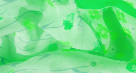 Blur of a green fabric with small floral patterns, featuring soft waves and dynamic folds. The light texture enhances the natural, fresh look of the fabric, ideal for nature-inspired designsの写真素材