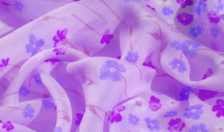 Blurred image of a soft lavender fabric with intricate floral patterns, featuring violet and blue...