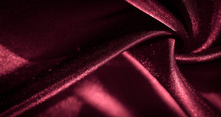 Blur the red satin fabric with soft lighting creates a luxurious and smooth texture. The rich color and elegant folds add depth and sophistication, evoking a sense of warmth and luxury.の写真素材