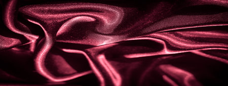 Blurred Silky Red Satin Fabric with Soft Pleats: Rich crimson satin flows in smooth, soft folds, its glossy surface catches the light, creating an elegant, luxurious textile designの写真素材