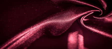 Blur of elegant red satin fabric with soft folds and deep shadows, showing its smooth texture and glossy finish, adding a touch of luxury and refinement to any creative design.の写真素材