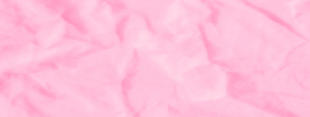 Blur of soft pink fabric with delicate folds creating smooth waves. The gentle lighting enhances the serene and feminine texture, adding an abstract aesthetic to the material.の写真素材