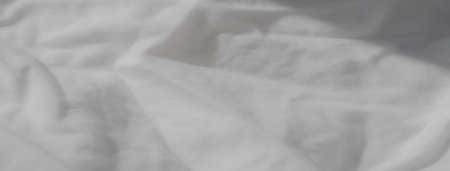 Blur of crumpled white fabric with subtle creases and folds. The soft texture adds a soothing...