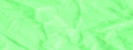 Blur of glowing green fabric with organic folds and smooth textures. The radiant green hue and fluid motion evoke a sense of nature, with the fabric resembling flowing water or lush leaves.の写真素材