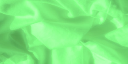 Blur of green satin fabric, featuring soft and fluid ripples across the material. The delicate green tone and smooth surface create a tranquil and refined textile design perfect for backgrounds.の写真素材