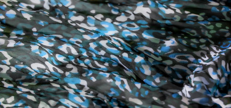 Blur of a colorful camouflage fabric in shades of blue, white, and green, captured in soft folds...