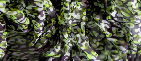 Blur of abstract green, black, and white patterns swirls across a fabric surface, blending modern...