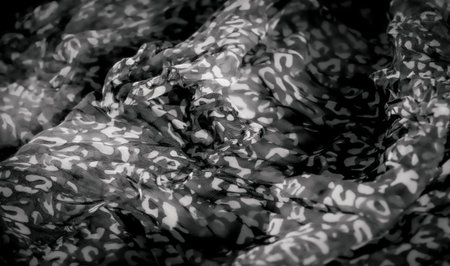 Blur of a striking black and white abstract fabric design, with delicate folds accentuating the...