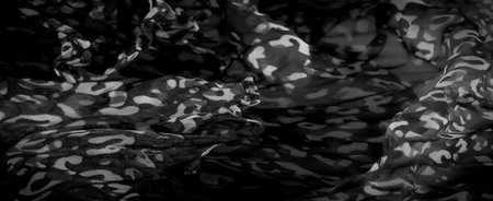 Blur of abstract light and dark patterns on soft, flowing fabric. The delicate folds create a...