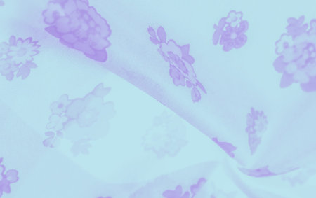 Blur effect accentuates the soft purple floral patterns on a light blue background, evoking a...