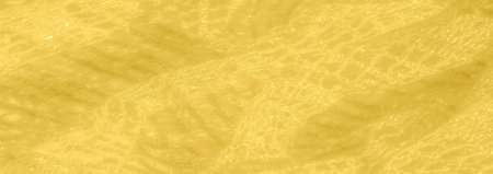 A washed out yellow lace fabric with shimmering threads and intricate patterns that create a soft...