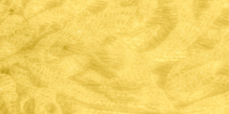 Blur of a pale yellow fabric with intricate shimmering patterns. The delicate weave and soft folds...