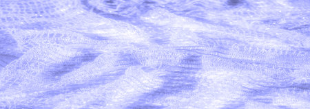A blurry close-up of light purple lace fabric, shimmering gently with soft reflections of light. The...