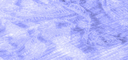 Blur of light violet lace fabric in a delicate and soft flowing pattern. The intricate lace weave...