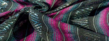 Blur of a black fabric with vibrant pink and purple stripes and woven shimmering accents, capturing...