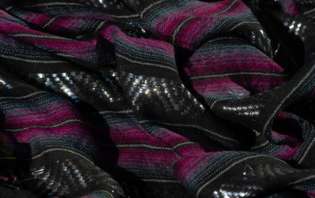 Blur: Luxurious black fabric with pink and blue woven accents, featuring glossy highlights that...
