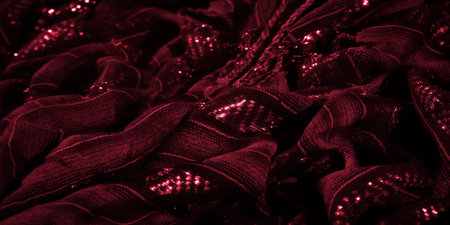 Blur of luxurious red fabric with intricate textures and glowing elements. The smooth folds and dramatic lighting make for an exquisite visual, suitable for high-end fashion and textile projects.の写真素材
