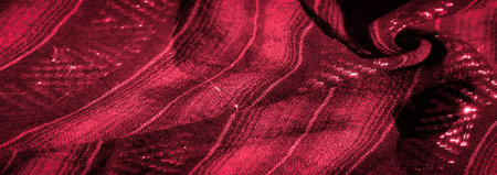 A striking red fabric with complex woven patterns and a glossy, reflective finish that highlights...