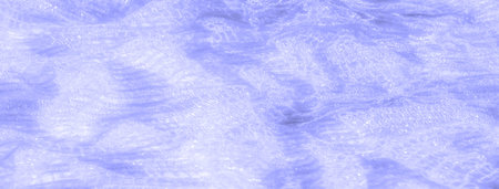 Blur of translucent blue lace fabric, featuring a blend of intricate patterns and shimmering light...