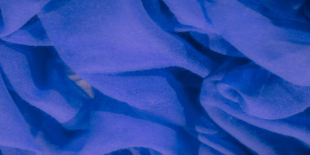 Blur of blue fabric cascading into smooth, soft folds. The intricate mesh texture adds an artistic touch, capturing light and shadow to create a dynamic, flowing composition.の写真素材