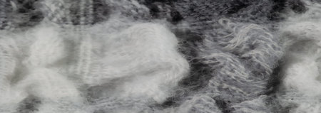 Blur - A macro view of white and gray wool fibers, artistically interlaced in a woven pattern. The...