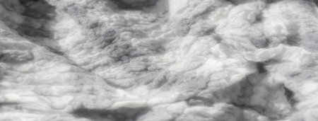 Blur the soft grayscale and white fabric textures, capturing the intricate details of the...