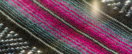 Blur The black fabric with bright pink and blue stripes creates a bold textured composition. The folds and woven elements of the textile are highlighted by the reflected light, adding depth and detailの写真素材