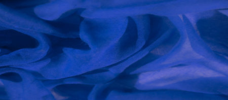 Blur of blue fabric creating intricate folds with a flowing, natural rhythm. The light softly...