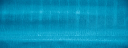 Blur of blue fabric with soft ridges and intertwined threads. The folds in the fabric create a sense...