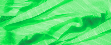 Blur: Bright green fabric with dynamic folds and thread details, offering a textured, abstract composition. The soft sheen adds depth to this eco-inspired textile design.の写真素材