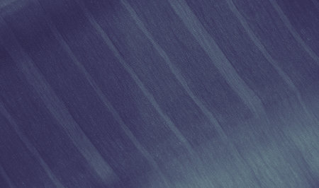 Blur smooth blue fabric with shimmering stripes undulates in soft folds, creating a sense of movement and texture. The calming color and delicate lines evoke elegance and softness.の写真素材