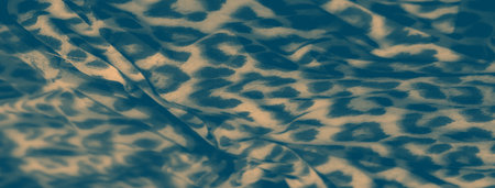 Blurred elegant fabric with soft beige and teal animal print patterns. The smooth texture and folds create a seamless visual effect, perfect for backgrounds, textile patterns, or design applications.の写真素材