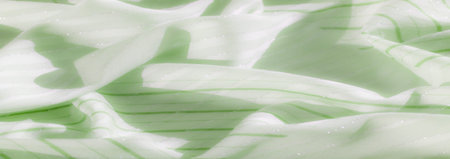 Blur of light and dark green fabric with shimmering silver highlights. The rippled texture creates a...