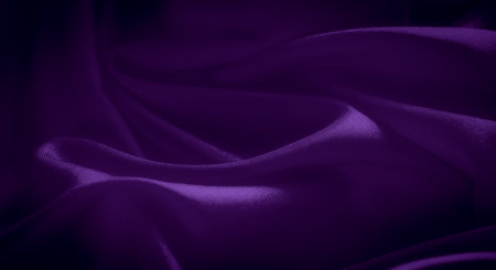 Blurred satin fabric in deep purple with gentle folds and a soft, glossy texture. The smooth and shiny surface reflects light, creating an elegant, sophisticated visual appeal.の写真素材