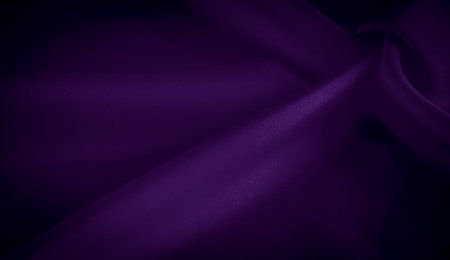 Blur of rich purple satin fabric twisted and gathered into soft folds, showing a reflective and shimmering surface. The fabric creates dynamic movement and a luxurious atmosphereの写真素材