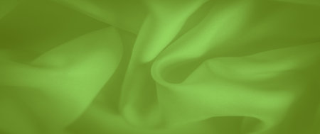 Blurred detailed close-up of bright green fabric with flowing folds, offering a smooth and soft surface, perfect for modern textile design or background elements.の写真素材