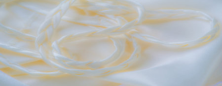 Blur of light fabric with braided accents, creating an interplay of shadows and textures that...