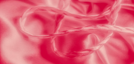 Blur of soft pink fabric captured in a smooth, flowing motion, creating gentle curves and folds. The...
