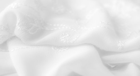 Blur Delicate white fabric with intricate embroidery folds, creating soft textures and elegant patterns. The subtle floral design adds a refined touch, perfect for sophisticated textile applications.の写真素材