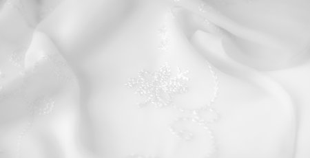 Blur. An elegant white fabric with intricate embroidery flowing softly in delicate folds. The luxurious texture and refined details make this material perfect for bridal fashion or high-end interiorの写真素材